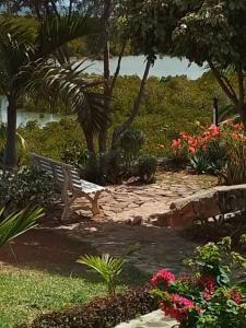 a park bench sitting in a garden with flowers at Villa baie diamant in Rodrigues Island