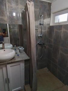 La salle de bains est pourvue d'une douche et d'un lavabo. dans l'établissement Villa baie diamant, à Rodrigues Island