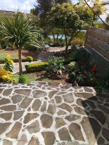 un jardin avec un chemin en pierre et un banc dans l'établissement Villa baie diamant, à Rodrigues Island