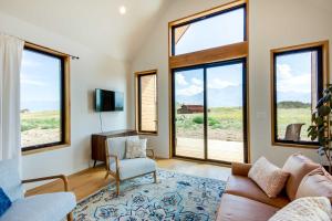 sala de estar con sofá, sillas y ventanas en Yellowstone Prairie Retreat 360 Mountain Views!, en Emigrant
