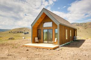 una pequeña casa de madera en medio de un campo en Yellowstone Prairie Retreat 360 Mountain Views!, en Emigrant