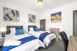 2 Betten in einem Zimmer mit Tisch und Stühlen in der Unterkunft Lincoln House Sleeps 6-8! Close to City and University! in Lincolnshire