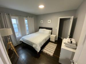 a small bedroom with a bed and a lamp at Luxury 3 bdr apt with backyard and off-street parking in Watertown