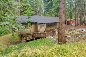 uma pequena casa com dois bancos na floresta em Secluded Arnold Vacation Rental Cabin with Game Room em Arnold