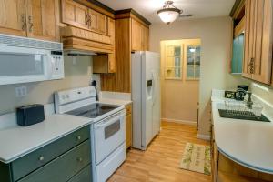 a kitchen with white appliances and wooden cabinets at Furnished Deck Secluded Arnold Cabin Rental! in Arnold