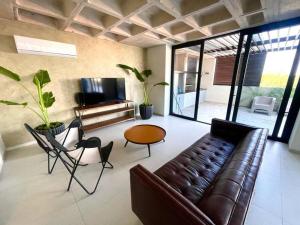 ein Wohnzimmer mit einer Ledercouch und einem Tisch in der Unterkunft Apartamento de lujo vistas 360° in Santa Cruz de la Sierra