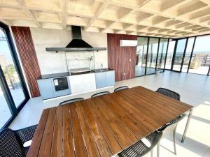 eine große Küche mit Holztisch und Stühlen in der Unterkunft Apartamento de lujo vistas 360° in Santa Cruz de la Sierra
