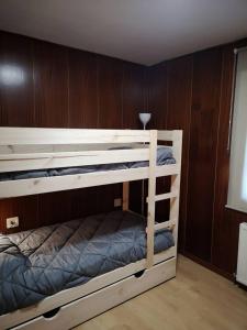Ce lit se trouve dans un dortoir doté de 2 lits superposés et de murs en bois. dans l'établissement Cal Boix Apartamento, à Tremp