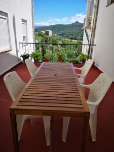 a wooden table and chairs on a balcony at Cal Boix Apartamento in Tremp
