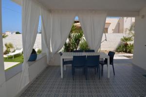 a table and chairs on a balcony with a view at Villa Colapesce in Marzamemi