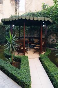 a wooden gazebo with a table in a garden at Mono Boutique Apartments in Tirana