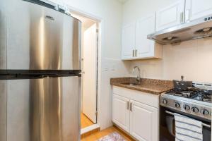 een keuken met een roestvrijstalen koelkast en een fornuis bij Large Queen Bed Apt with Workstation in New York