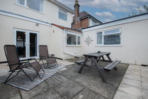 un patio con 2 sillas y una mesa de picnic en Cosy home from home, en Bournemouth