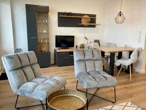 a living room with two chairs and a table at Monopol 106 in Wangerooge