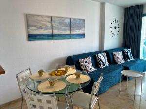 sala de estar con mesa y sofá azul en A897 - Atrium Beach 3 - 2004 Finestrat, en Villajoyosa