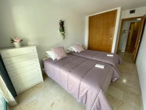 1 dormitorio con 2 camas con sábanas moradas y vestidor en A897 - Atrium Beach 3 - 2004 Finestrat, en Villajoyosa