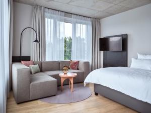 a bedroom with a bed and a couch and a table at STAYERY Bremen in Bremen