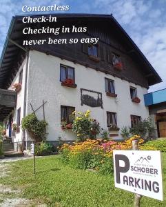 a sign in front of a building with a house at Sportpension Schober in Obertraun