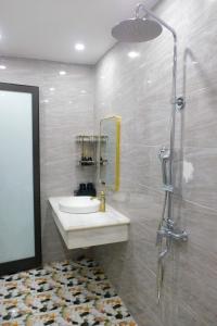 a bathroom with a sink and a shower at Royal Homestay - Royal Center in Móng Cái