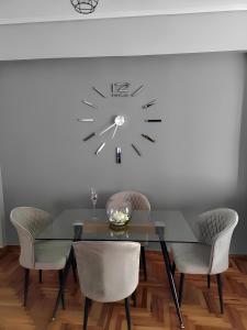 een eetkamer met een tafel en een klok aan de muur bij Εlite Αpartment Trikala in Tríkala