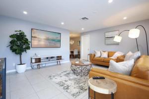 Greenacres CityThe Utopia Resort Dream Pool BBQ Outdoor Dining的客厅里有一张沙发和一张桌子。