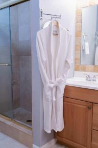 a white robe hanging on a towel rack in a bathroom at The Utopia Resort Dream Pool BBQ Outdoor Dining in Greenacres City