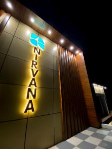 a sign on the side of a building at night at The Nirvana Resort in Chatra