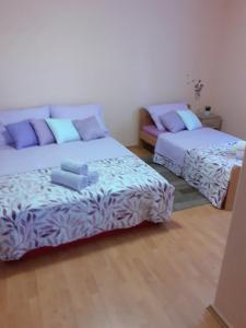 a bedroom with two beds and a couch at Apartman Blazenka in Viskovo