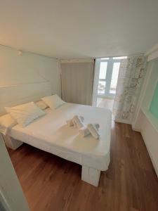 Una cama blanca con dos toallas en una habitación en Pipe- SweethomeRooms Cabo de Palos, en Cabo de Palos