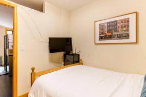 a bedroom with a bed and a flat screen tv at 2 Bedroom King Bed Apartment in New York