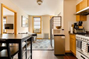 eine Küche und ein Wohnzimmer mit einem Tisch und Geräten in der Unterkunft 2 Bedroom King Bed Apartment in New York