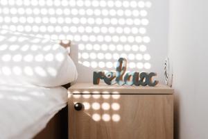 un bloc en bois avec le mot raemia assis sur un lit dans l'établissement Villa Mia, à Prnjavor
