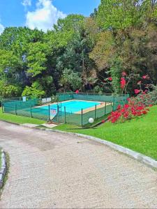 una valla alrededor de una piscina en un parque en Appartement cosy dans résidence avec piscine, en Fort-de-France