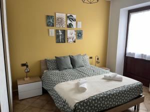1 dormitorio con cama y pared amarilla en [The window On The Valdadige] Sport and Nature, 