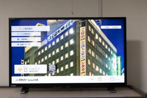a television screen with a building on it at Kurashiki Station Hotel in Kurashiki