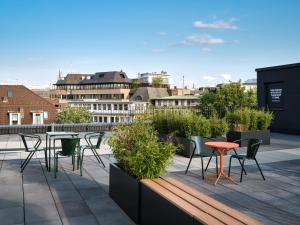 a patio with chairs and tables on a roof at STAYERY Bremen in Bremen