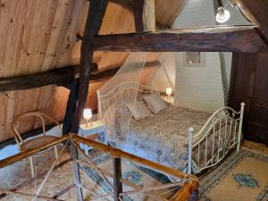 Petite maison Normande في Bellou-en-Houlme: غرفة نوم بسرير في العلية