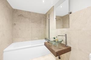 a bathroom with a sink and a bath tub at Luxury 3 bedroom house in Limehouse, close to city! Sleeps 6-8! in London