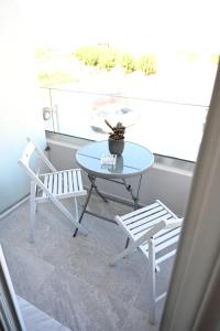 uma mesa e duas cadeiras sentadas numa varanda em Costa Varda Apartments em Mourteri