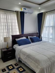 a bedroom with a large bed with blue pillows at Home away from home #1 in Accra