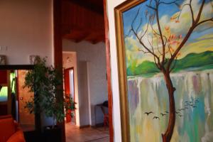 a painting of a tree on a wall in a room at 2 Kitarat BB in Vlorë
