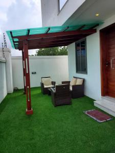 una pérgola en una casa con césped verde en Home away from home #1 en Accra