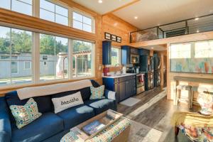 a living room with a blue couch and a kitchen at Shared Outdoor Pool and Patio Whitney Retreat! in Whitney