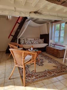 a living room with a table and a couch at Petite maison Normande in Bellou-en-Houlme