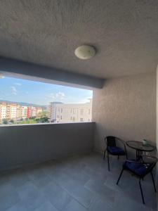une chambre avec une table, deux chaises et une fenêtre dans l'établissement Dari guesthouse, à Râmnicu Vâlcea