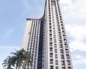 a tall white building with a palm tree in front of it at Maravilhoso Flat em Frente ao Aeroporto de Congonhas H1908 in Sao Paulo