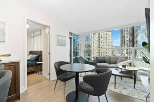 uma sala de estar com um sofá, uma mesa e cadeiras em 2BR Condo with breathtaking view in Downtown! Free parking - 6 sleep em Vancouver