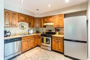 a kitchen with wooden cabinets and a white refrigerator at Cabin w hot tub & fire pit near Cacapon in Berkeley Springs