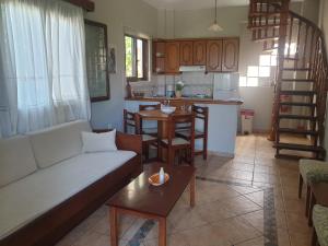a living room with a couch and a kitchen at Ostria Maisonettes and Studios in Stoupa