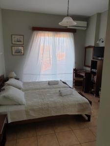 una camera con un grande letto e una finestra di Ostria Maisonettes and Studios a Stoupa